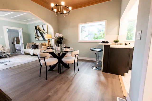 a view of a dining room with furniture a chandelier and wooden floor