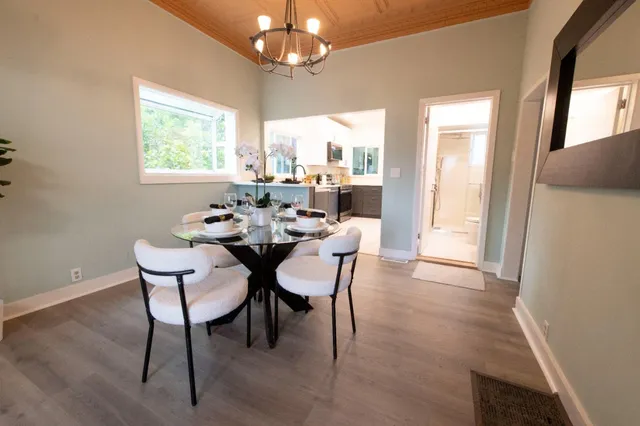 a dining room with furniture a chandelier and wooden floor