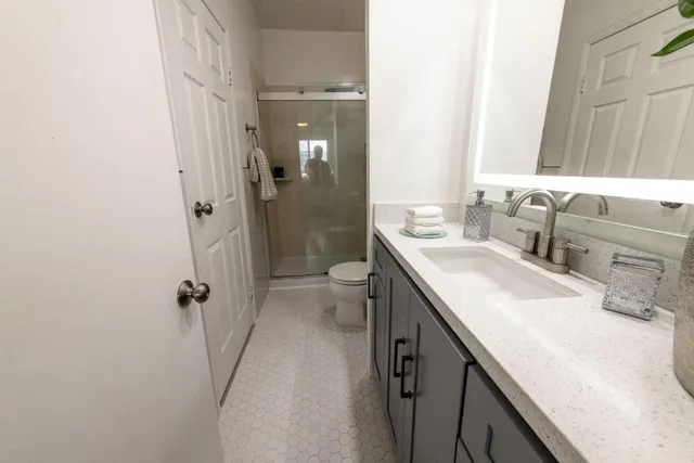 a bathroom with a granite countertop sink a mirror and a toilet