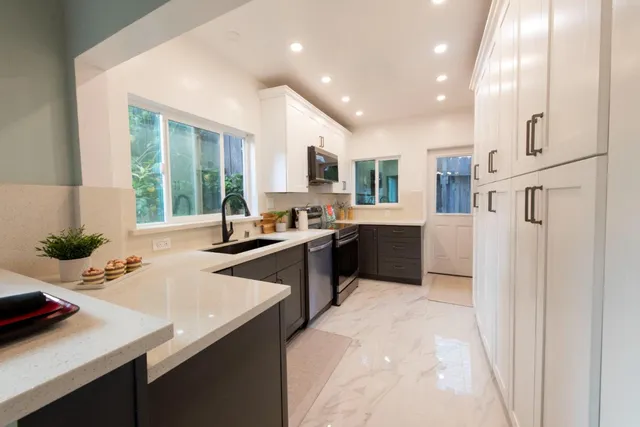 a kitchen with stainless steel appliances kitchen island granite countertop a sink and a refrigerator