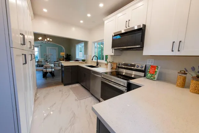 a kitchen with stainless steel appliances a stove a sink a microwave a refrigerator and cabinets