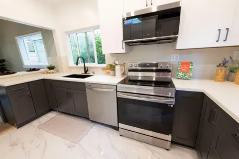 a kitchen with stainless steel appliances a stove a sink and a microwave
