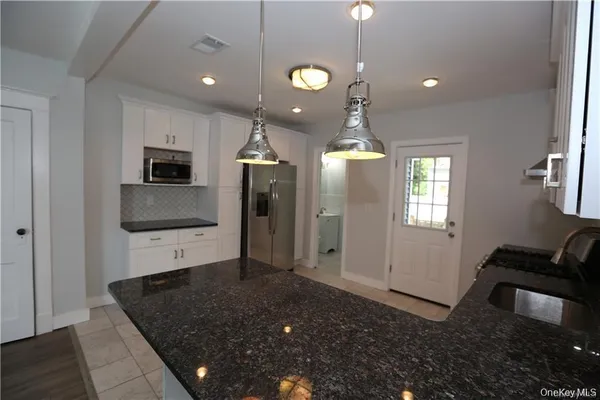 a view of a kitchen with a sink and dishwasher wooden floor