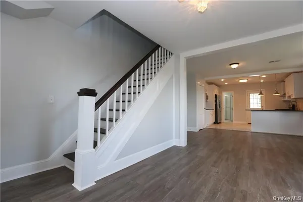 a view of entryway and hall with wooden floor
