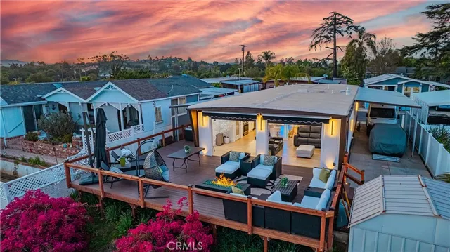 a view of a house with wooden deck and furniture