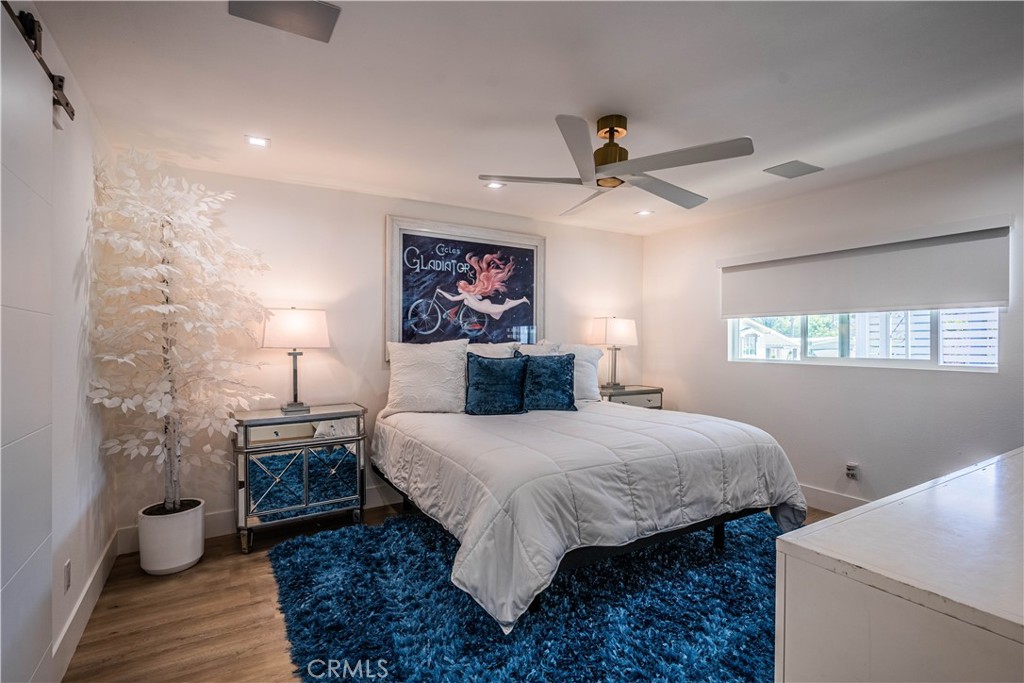 1120 East Mission Road, Unit 102 Fallbrook, CA 92028 - Photo 27 of 62 a bedroom with a bed and a chandelier