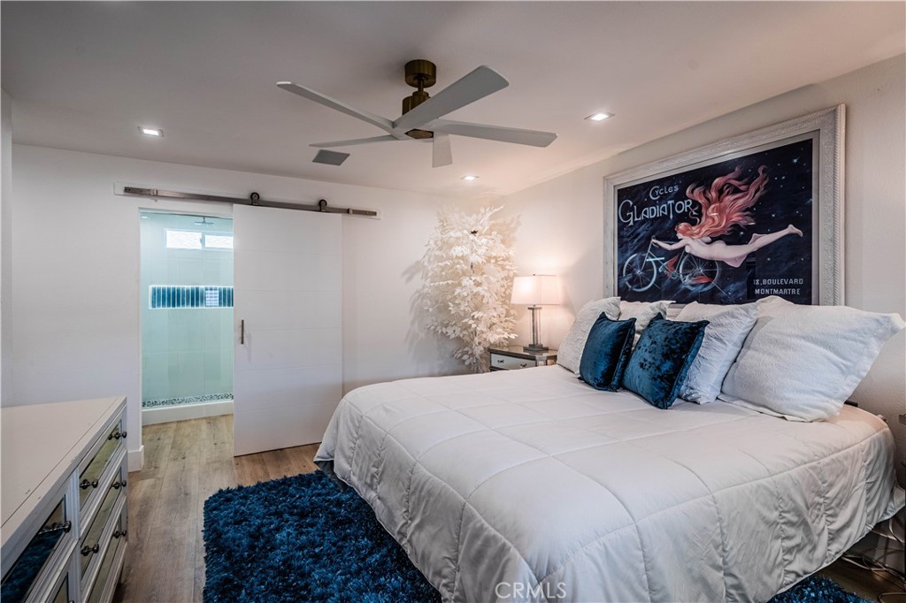 1120 East Mission Road, Unit 102 Fallbrook, CA 92028 - Photo 28 of 62 a bedroom with a large bed and a chandelier