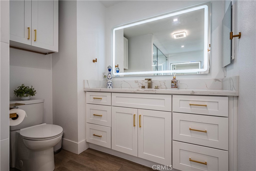 1120 East Mission Road, Unit 102 Fallbrook, CA 92028 - Photo 30 of 62 a bathroom with a toilet a sink and mirror