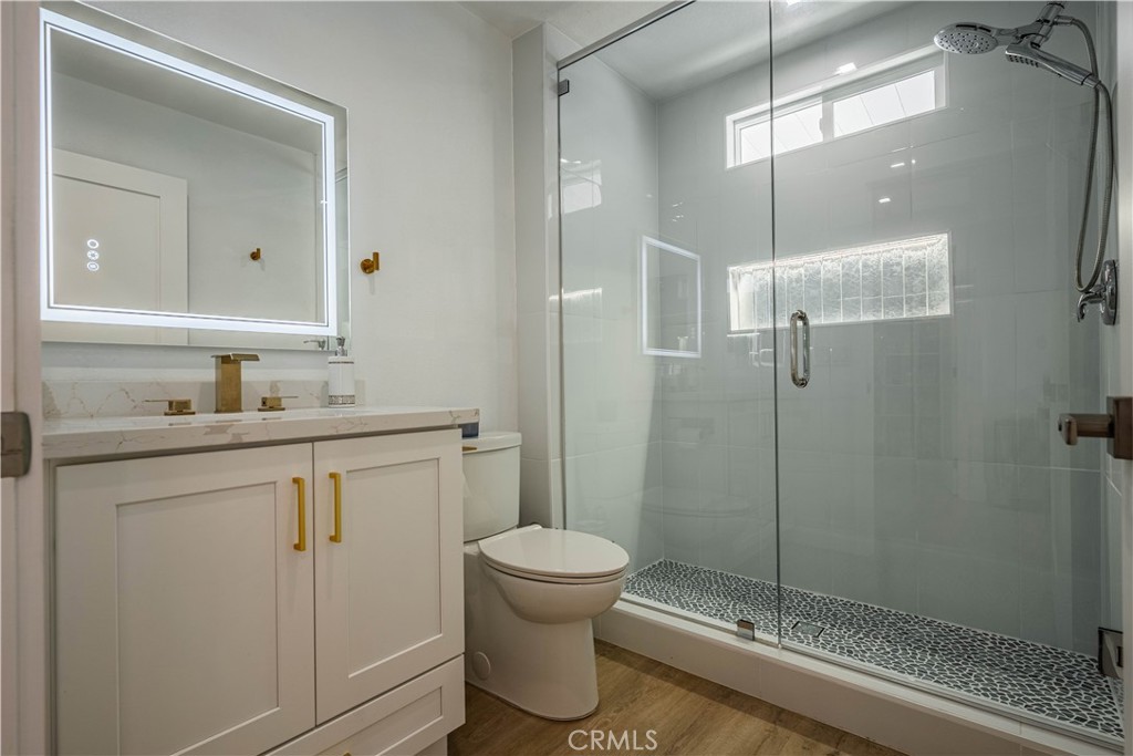 1120 East Mission Road, Unit 102 Fallbrook, CA 92028 - Photo 34 of 62 a bathroom with a shower sink vanity and toilet