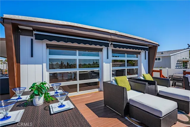 a view of a deck with couches table and chairs with wooden floor and fence