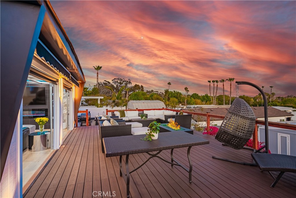 1120 East Mission Road, Unit 102 Fallbrook, CA 92028 - Photo 45 of 62 a view of a deck with couches table and chairs with wooden floor and fence