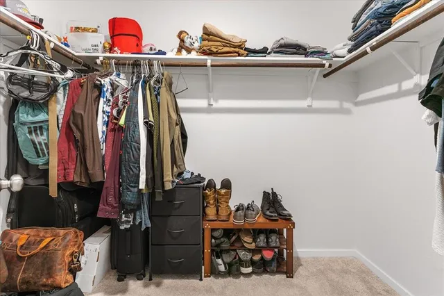 a view of walk in closet with clothes and shoes