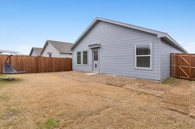 a view of a house with wooden fence
