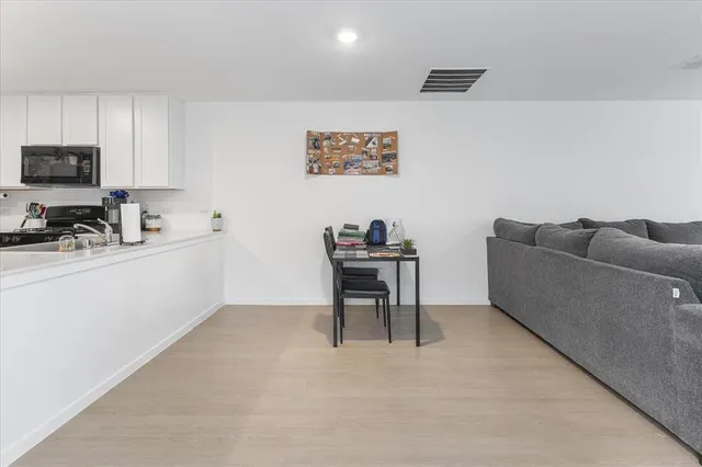 a work room with furniture a flat screen tv and a window
