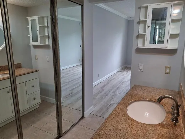 a bathroom with a granite countertop sink and a mirror