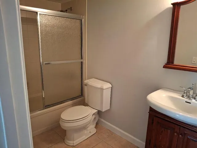 a white toilet sitting next to a shower