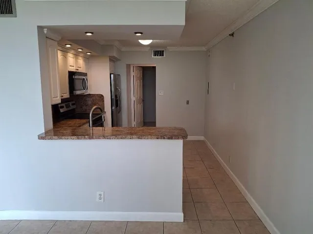 a view of kitchen with stainless steel appliances granite countertop window
