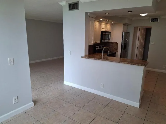 a view of kitchen with refrigerator and window