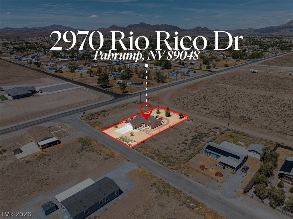 Aerial view shows the desert property boundaries outlined against a backdrop of distant mountains.