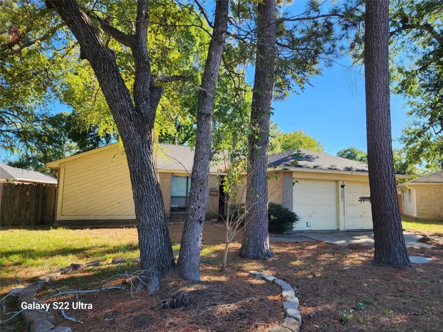 a view of a house with backyard and a tree