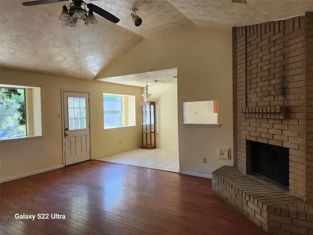 wooden floor in an empty room with a fireplace