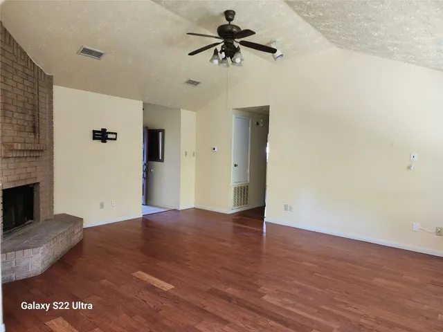 a view of a livingroom with a fireplace and wooden floor