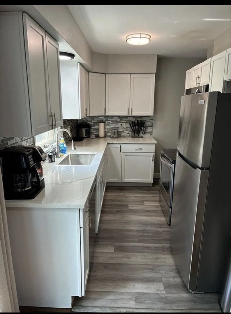 436 Springhill Drive Roselle, IL 60172 - Photo 4 of 11 a kitchen with a sink stainless steel appliances and white cabinets