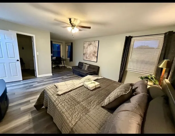 a bedroom with a bed and wooden floor