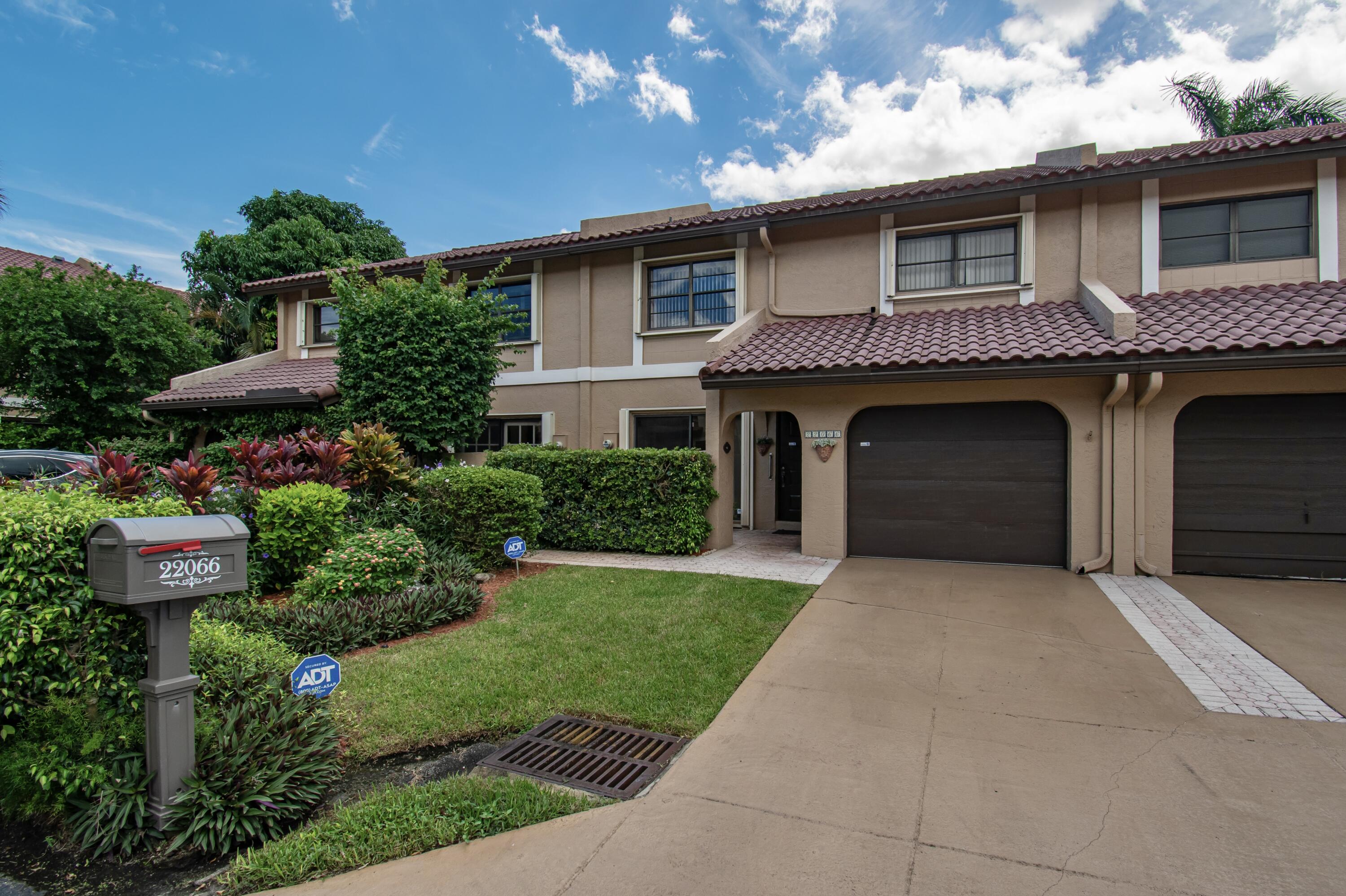 a front view of a house with a garden and plants