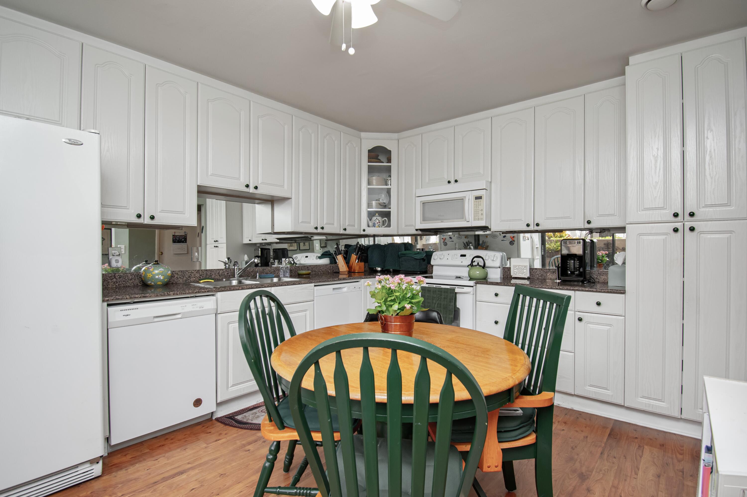 22066 Las Brisas Circle Boca Raton, FL 33433 - Photo 13 of 45 a kitchen with stainless steel appliances granite countertop a dining table chairs refrigerator and sink