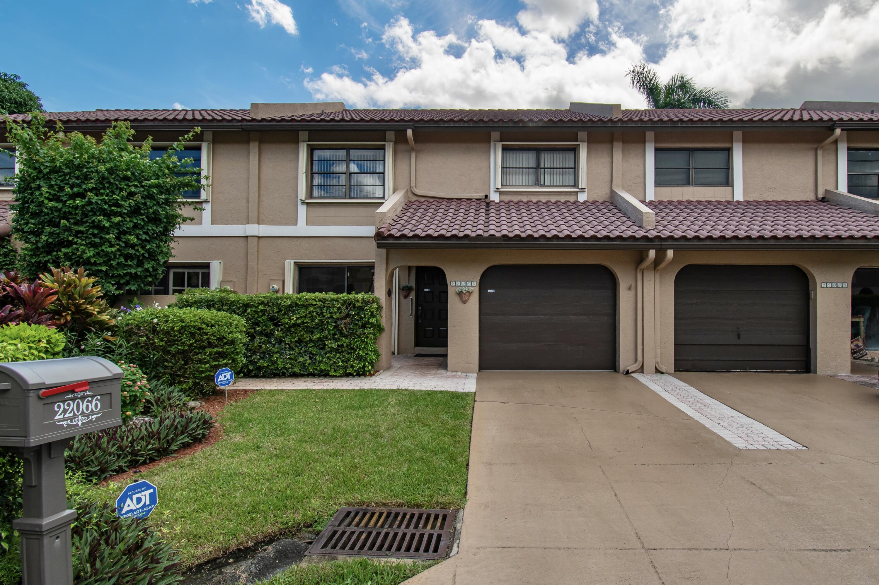 22066 Las Brisas Circle Boca Raton, FL 33433 - Photo 2 of 45 a front view of a house with a garden and plants