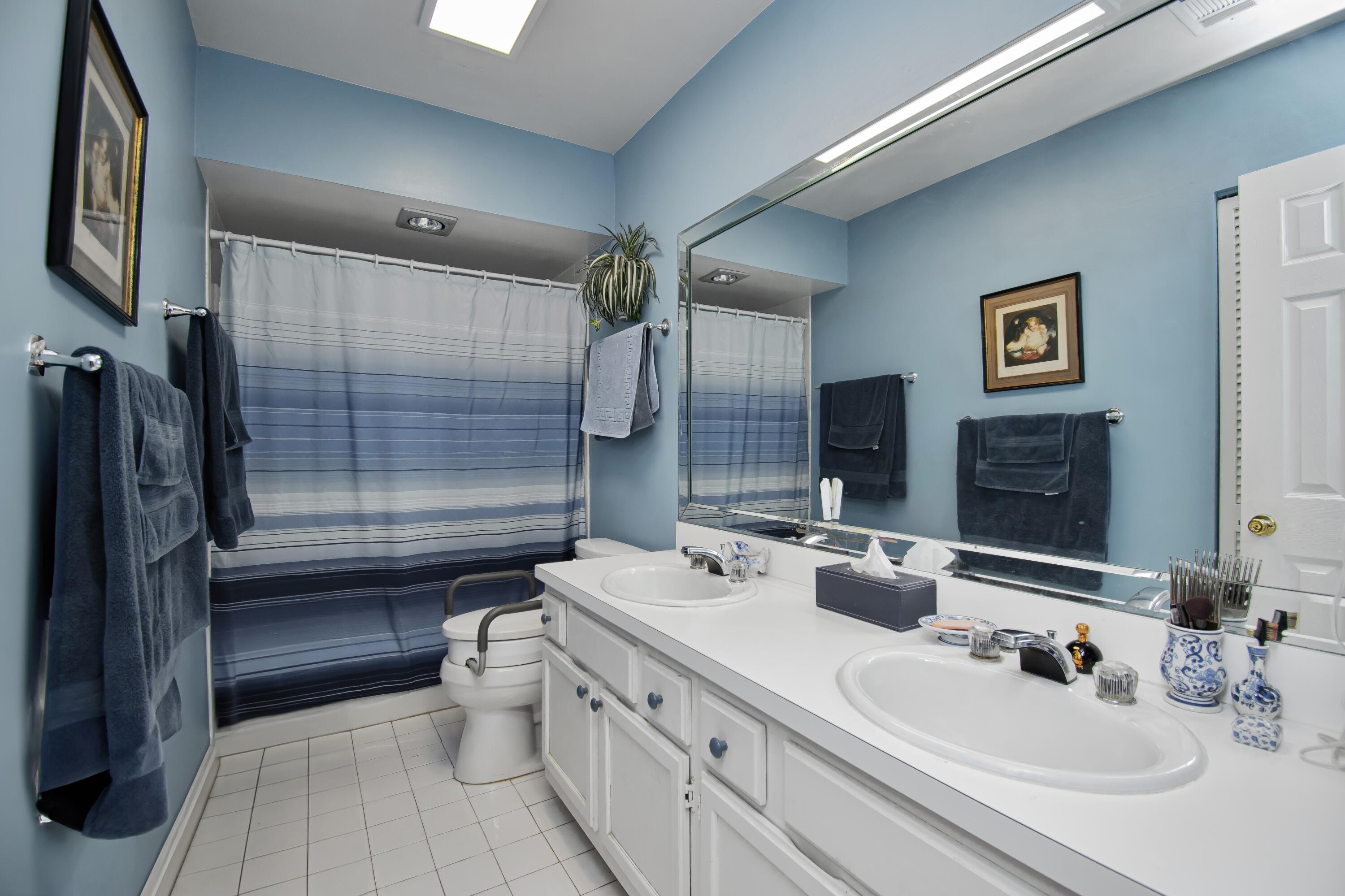 22066 Las Brisas Circle Boca Raton, FL 33433 - Photo 30 of 45 a bathroom with a double vanity sink toilet and shower