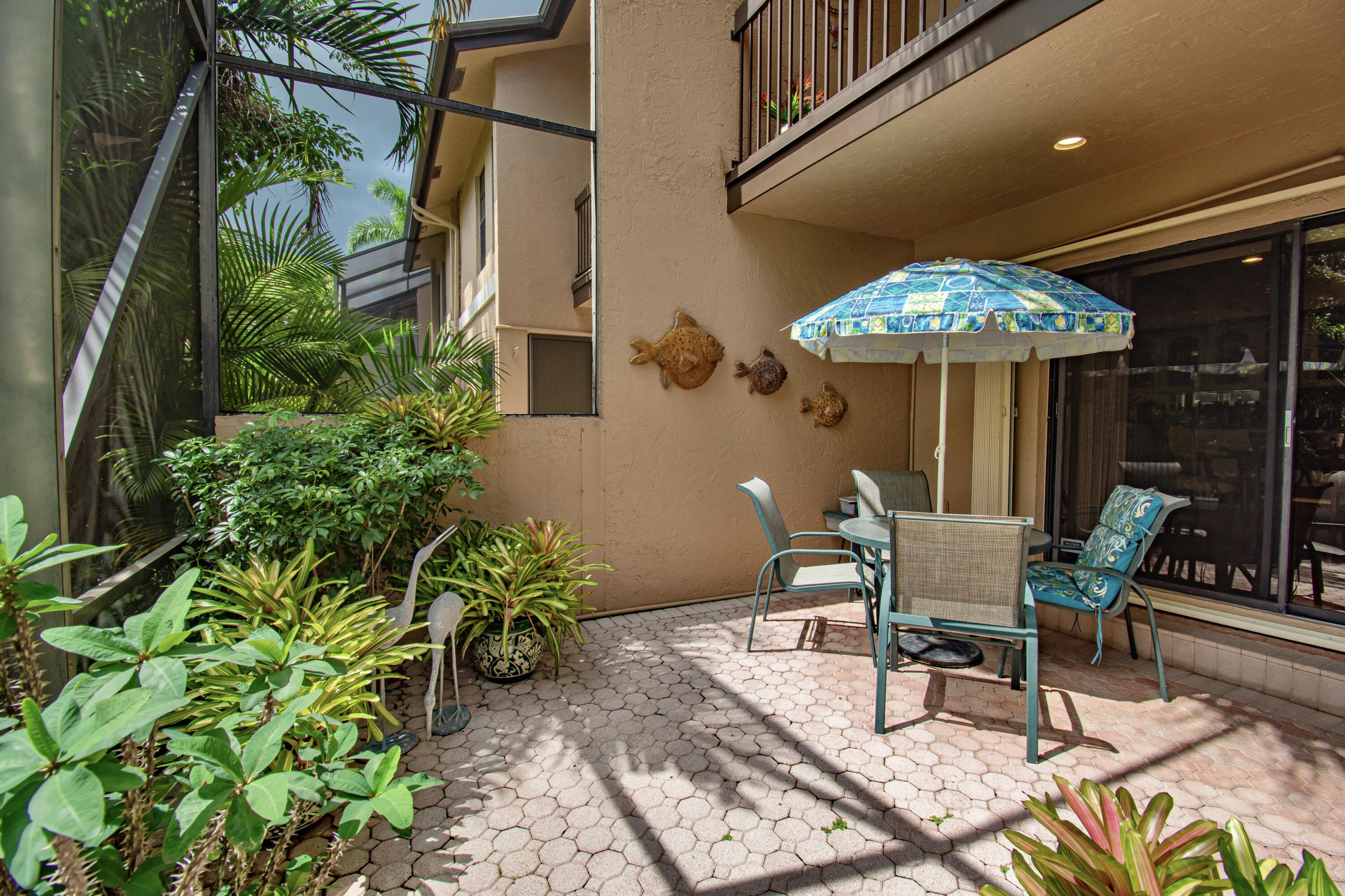 22066 Las Brisas Circle Boca Raton, FL 33433 - Photo 37 of 45 a view of a patio with table and chairs potted plants