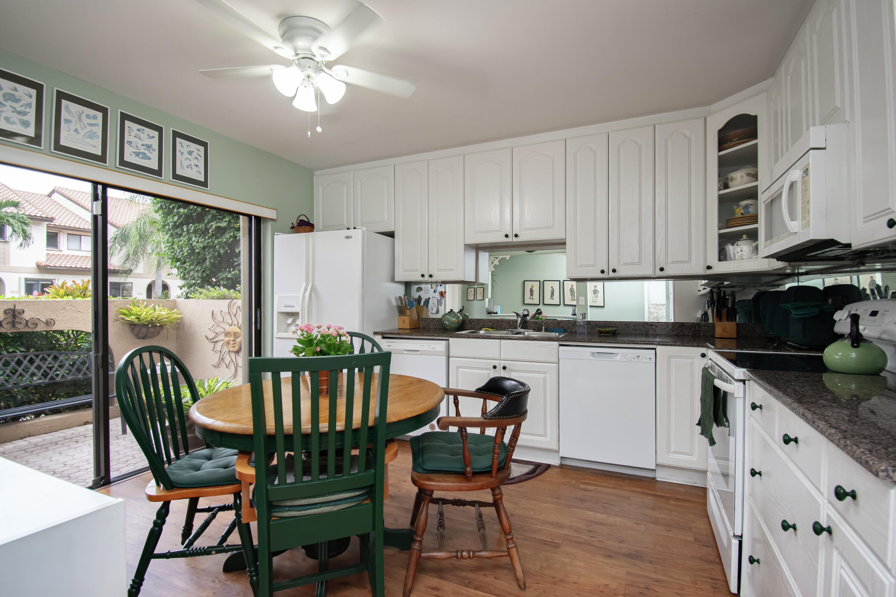 22066 Las Brisas Circle Boca Raton, FL 33433 - Photo 9 of 45 a kitchen with a dining table chairs and refrigerator