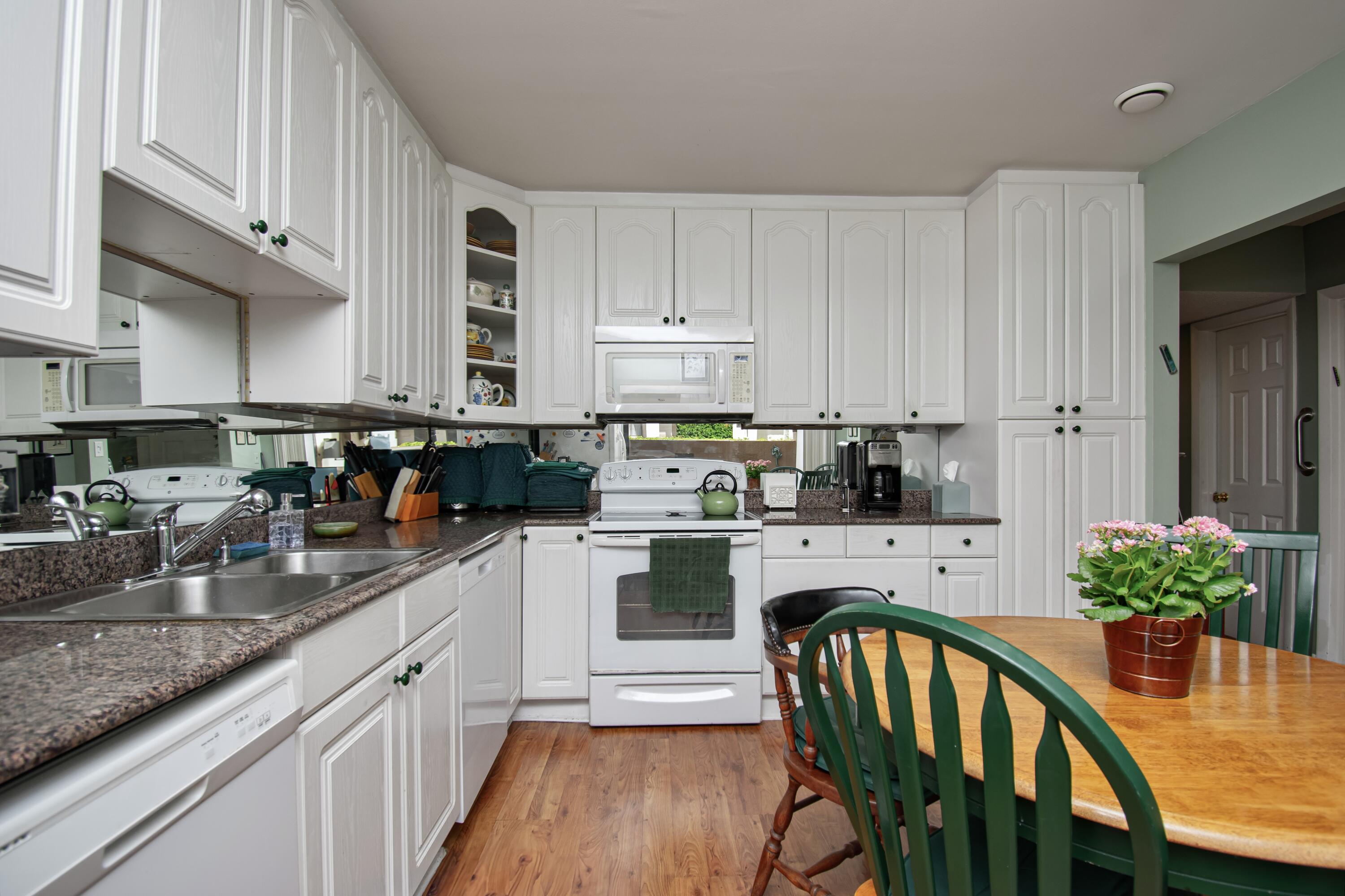 22066 Las Brisas Circle Boca Raton, FL 33433 - Photo 10 of 45 a kitchen with stainless steel appliances granite countertop a stove top oven a refrigerator a sink and dishwasher with wooden floor