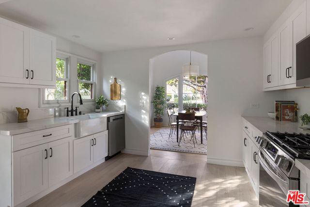 a kitchen with white cabinets and stainless steel appliances