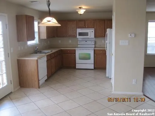 a kitchen with kitchen island granite countertop a sink and a stove