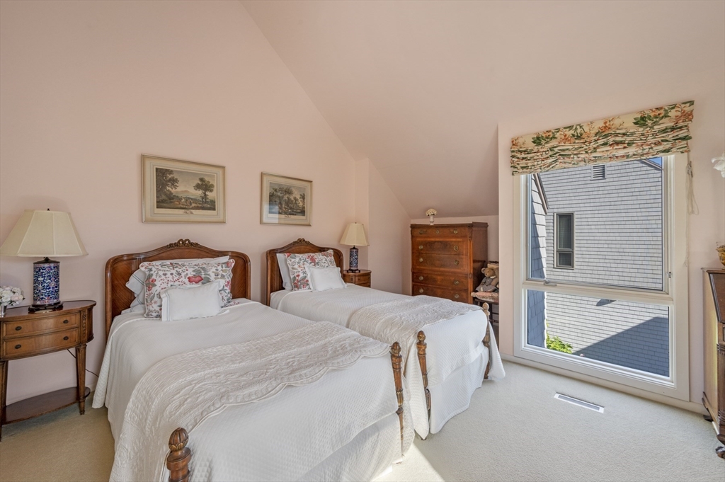 9 Skinner's Path, Unit 9 Marblehead, MA 01945 - Photo 17 of 23 a bedroom with a bed and a chandelier