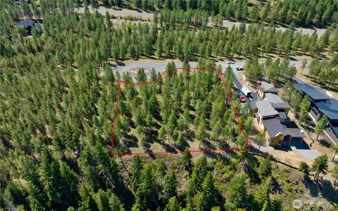an aerial view of residential houses with outdoor space and trees