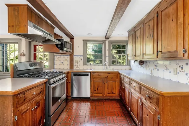 a kitchen with stainless steel appliances granite countertop a stove a sink and a refrigerator