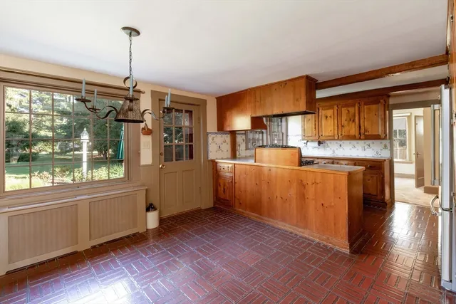 a kitchen with stainless steel appliances granite countertop a refrigerator a sink dishwasher a stove and white countertops with wooden floor