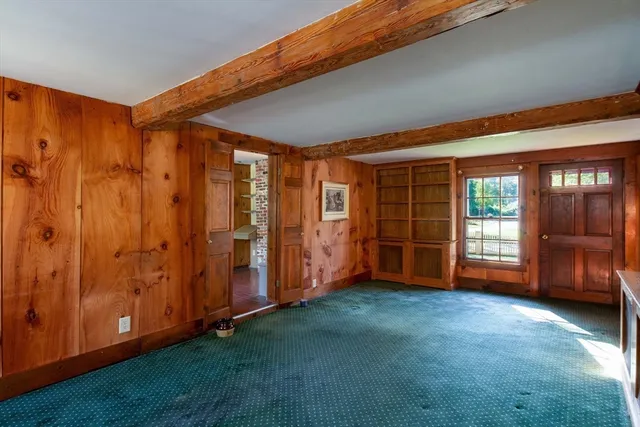 a view of an empty room with closet and a window