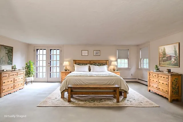 a bedroom with a bed a dresser next to a window