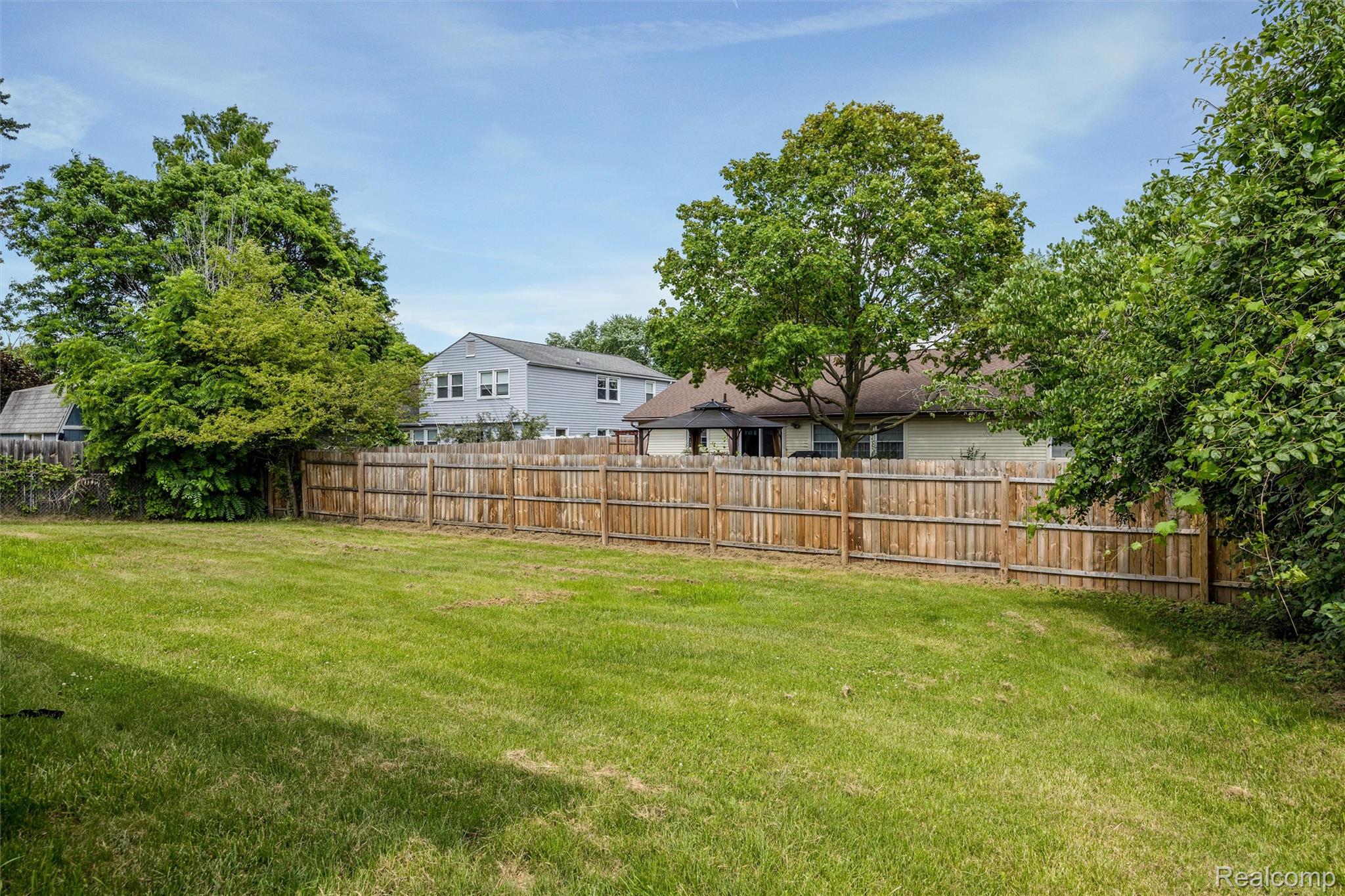 4942 Butler Drive Troy, MI 48085 - Photo 33 of 33 Expansive green space featuring a wooden privacy fence