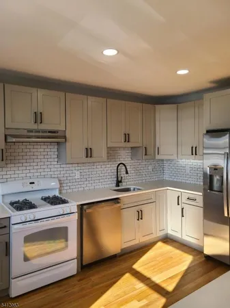 a kitchen with kitchen island granite countertop a stove sink and cabinets