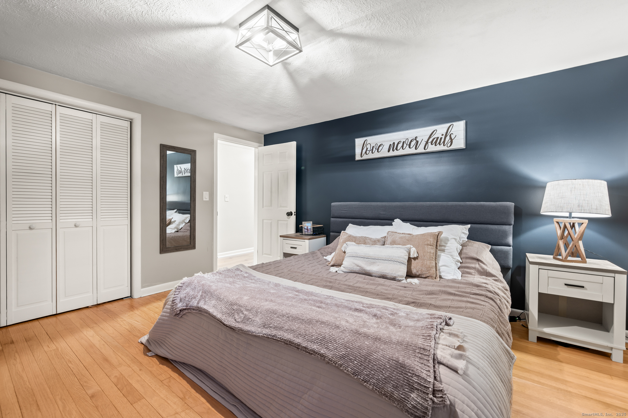 24 William Street Portland, CT 06480 - Photo 14 of 35 a bedroom with a large bed and a chandelier