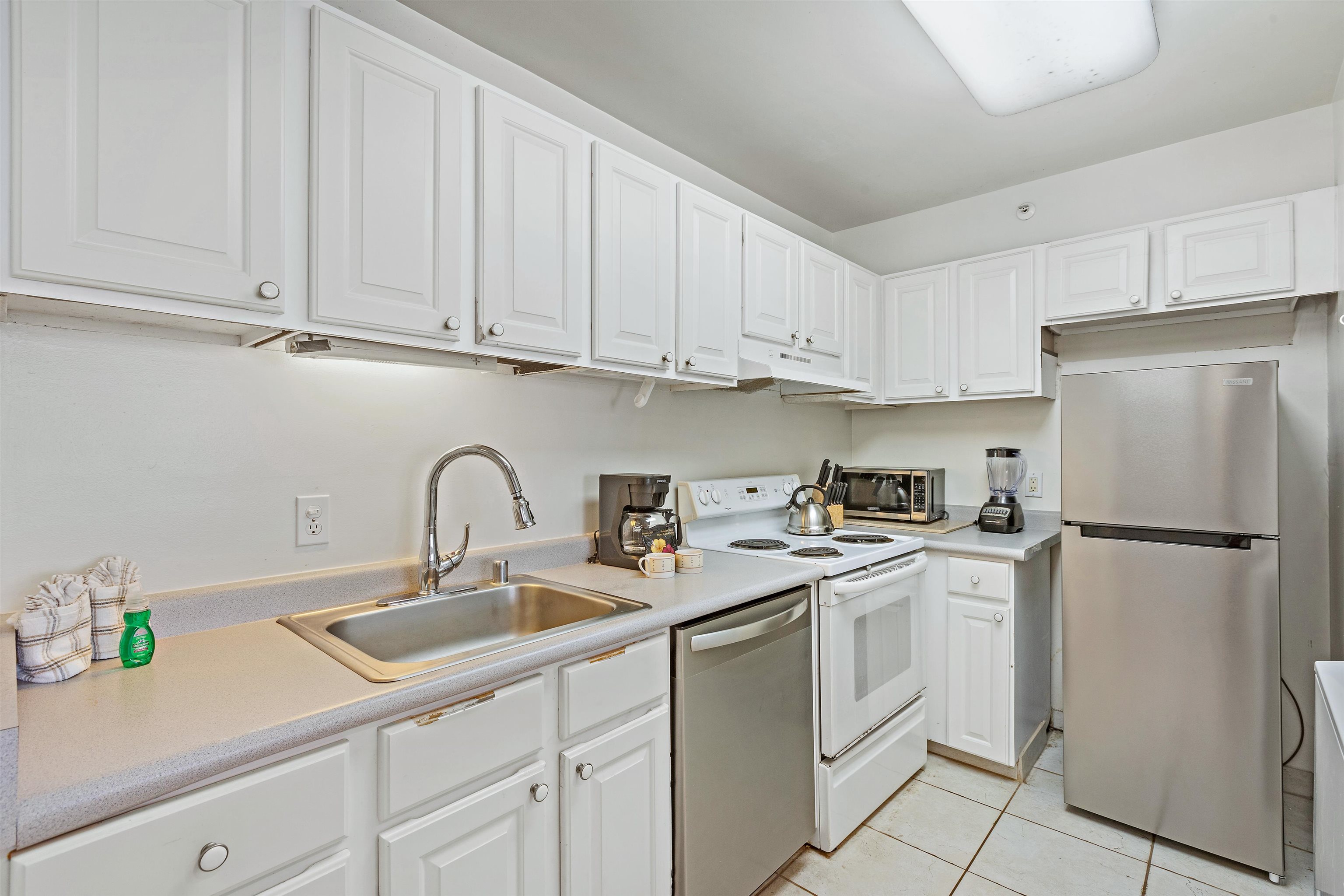 4327 Lower Honoapiilani Road, Unit 808 Lahaina, HI 96761 - Photo 12 of 35 a kitchen with appliances a sink a refrigerator and cabinets