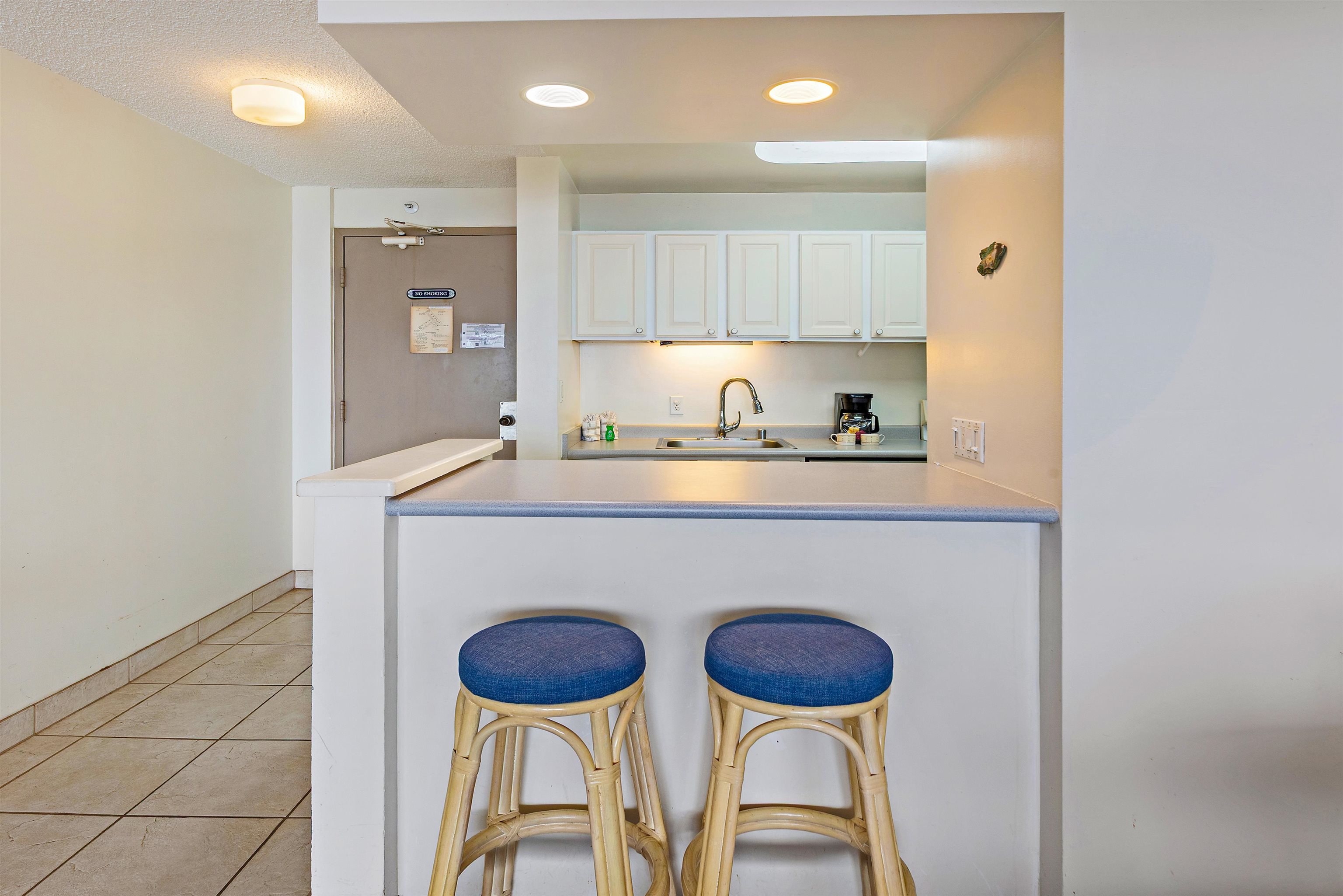 4327 Lower Honoapiilani Road, Unit 808 Lahaina, HI 96761 - Photo 14 of 35 a kitchen with a table chairs stove and cabinets