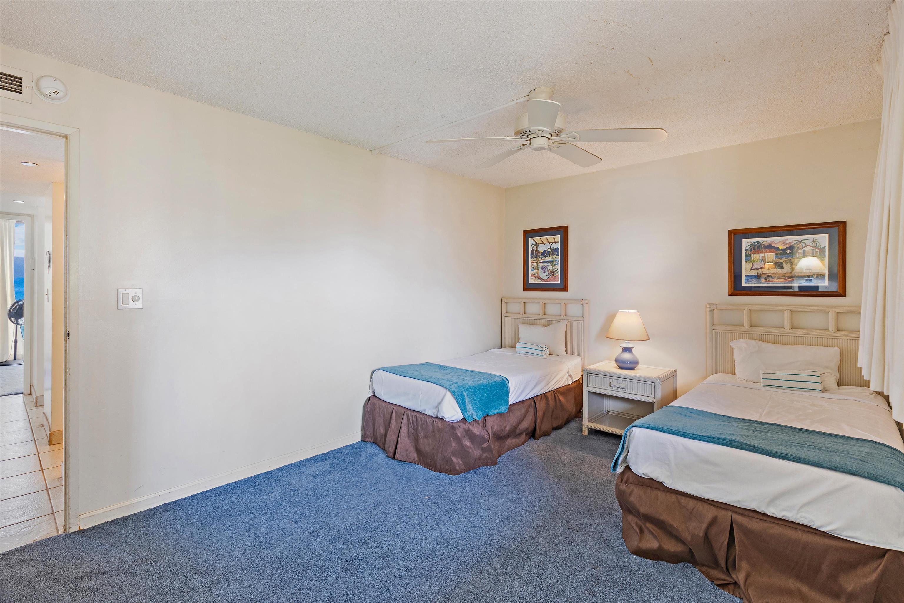 4327 Lower Honoapiilani Road, Unit 808 Lahaina, HI 96761 - Photo 24 of 35 a spacious bedroom with two beds and painting on the wall