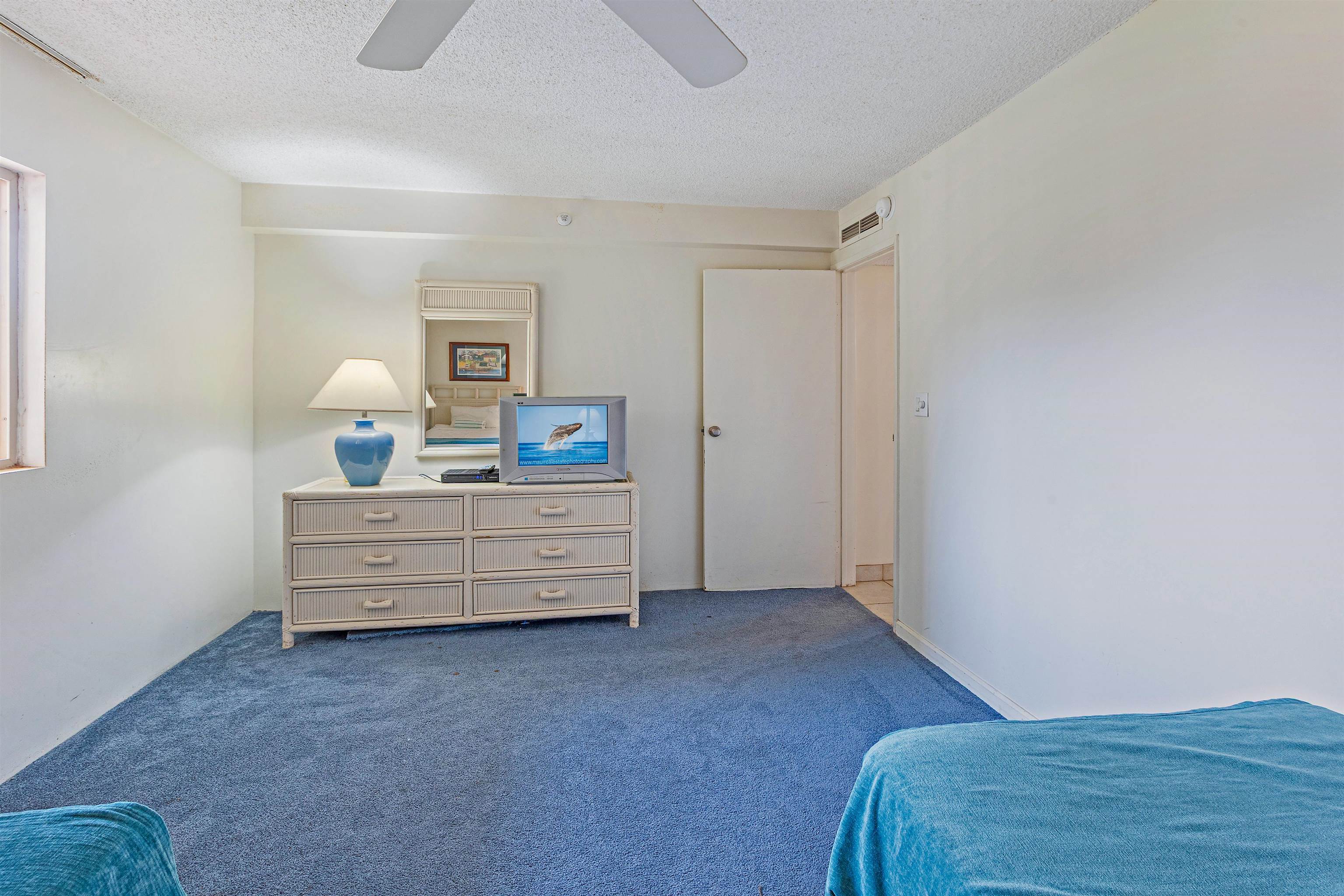 4327 Lower Honoapiilani Road, Unit 808 Lahaina, HI 96761 - Photo 25 of 35 a room with a bed and a dresser